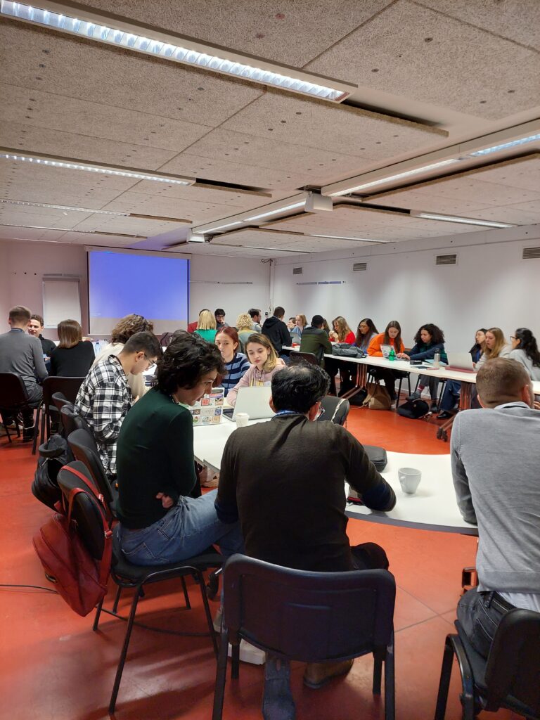 Participants of the workshop working together in a seminar room sitting at a u-shaped desk